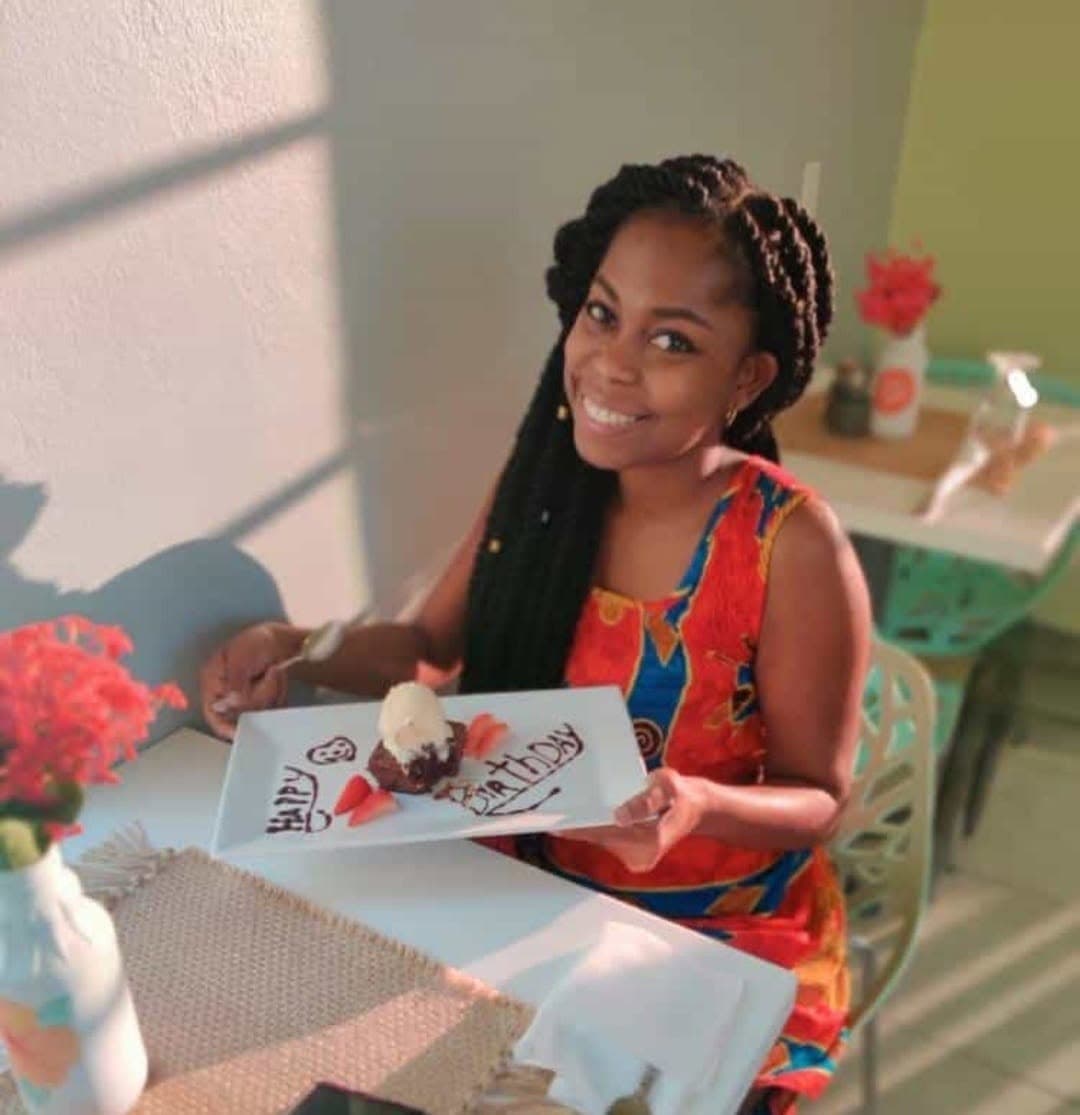 A guest celebrating her birthday with a hand-written chocolate dessert plate on the veranda