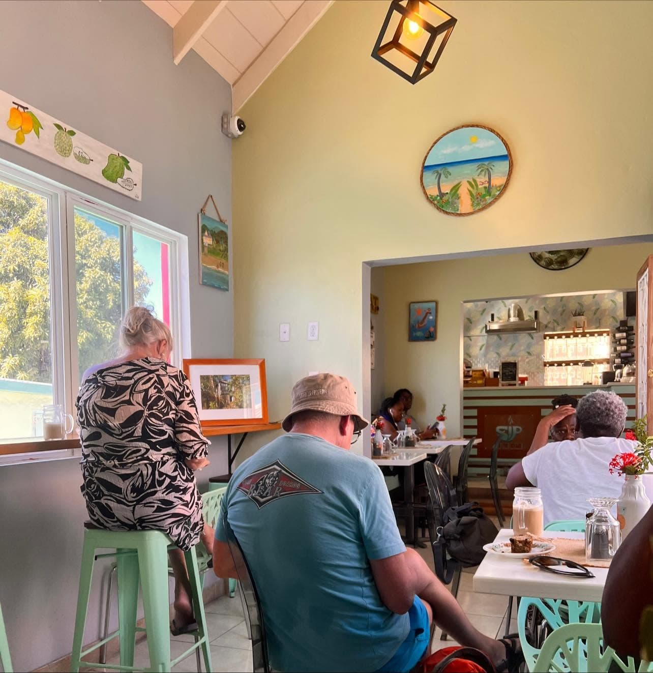 A wide view inside the café, guests seated beneath the vaulted, beam-lined ceiling