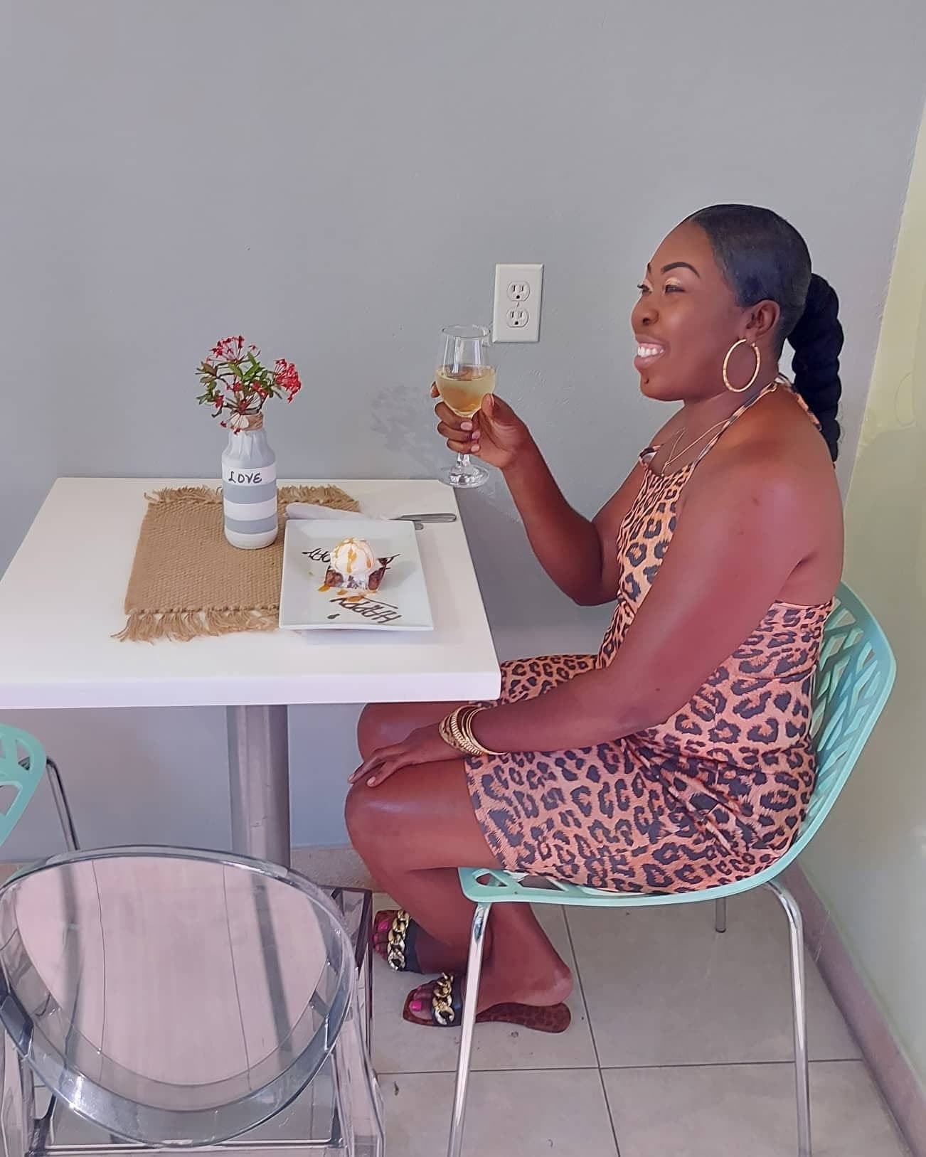 A guest celebrating a birthday at an indoor table, with a dessert plate and a glass of wine