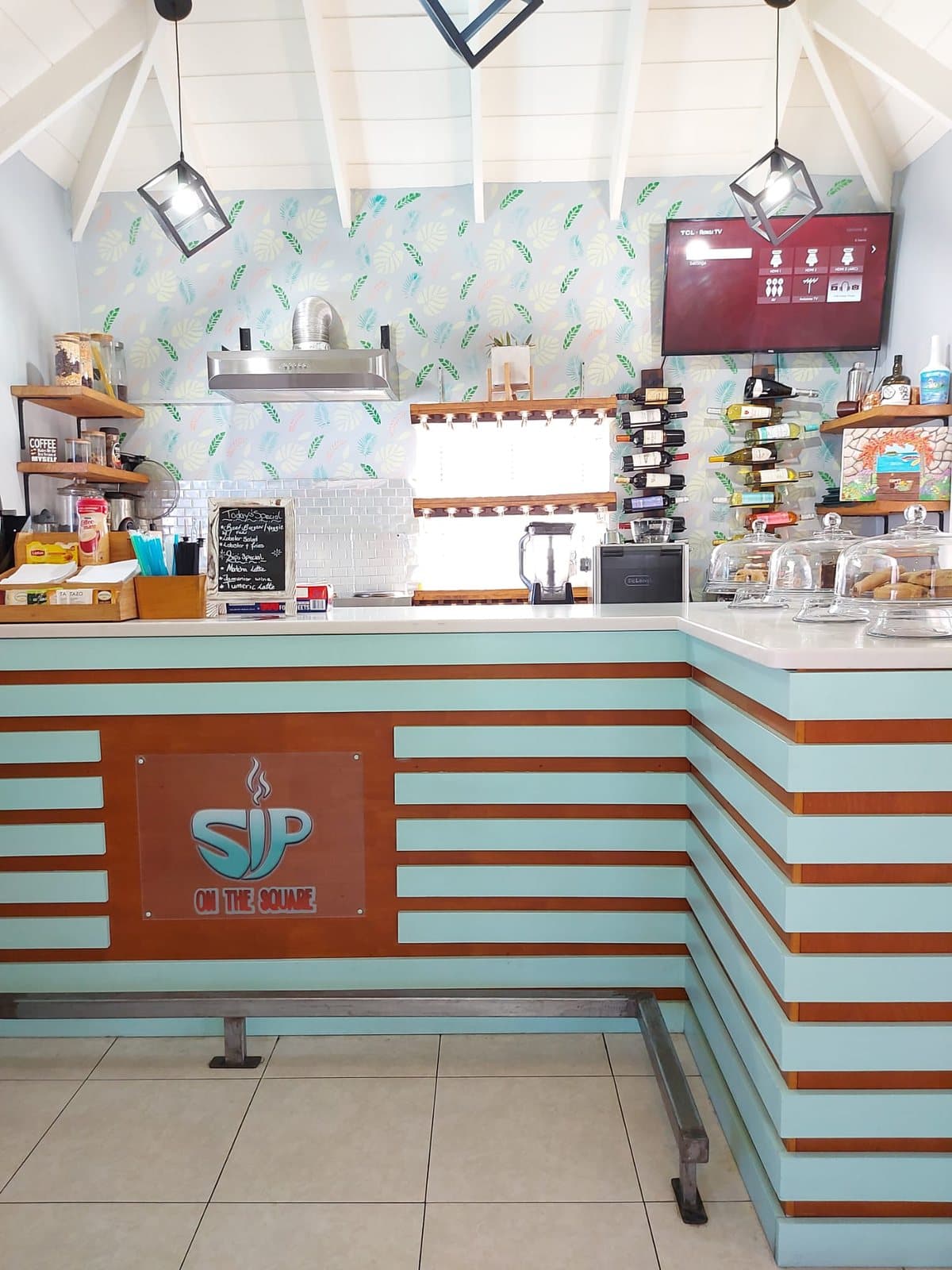 The Sip On The Square counter, the logo on its wooden front and the day's specials board beside it